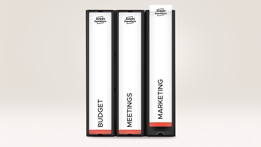 Tri crna ormarića za spise koji stoje jedan pored drugog s bijelim etiketama na leđima. Na etiketama pišu riječi "BUDŽET", "SASTANCI" i "MARKETING" te je na vrhu Avery Zweckform logo.