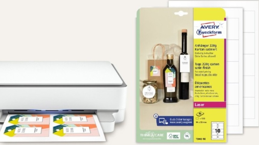 Bijeli uredski pisač ispisuje šarene etikete, a pokraj njega je pakiranje kartonskih privjesnica Avery Zweckform s primjerima etiketa na staklenkama i bocama.