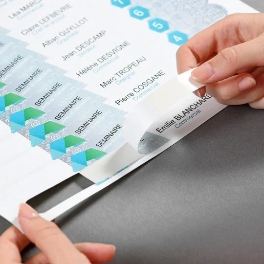 Osoba odvaja jednu, ispisanu identifikacijsku narukvicu s perforiranog lista papira