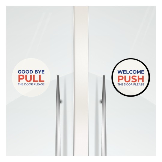 Dvije okrugle naljepnice na staklenim vratima s uputama. Lijeva naljepnica ima natpis "GOOD BYE PULL THE DOOR PLEASE", a desna "WELCOME PUSH THE DOOR PLEASE".
