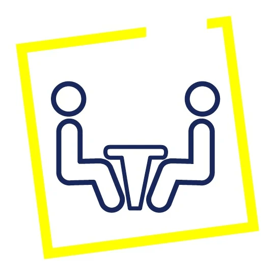 Ikona dwóch osób siedzących przy stole w żółtej ramce, symbol spotkania.