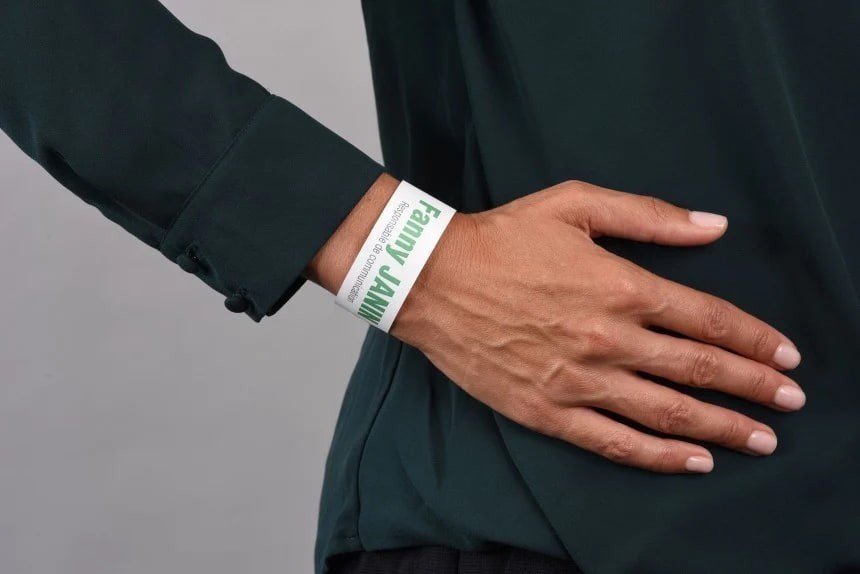 Zapešće osobe s bijelom identifikacijskom narukvicom na kojoj je zeleni tisak "Fanny JANIN"