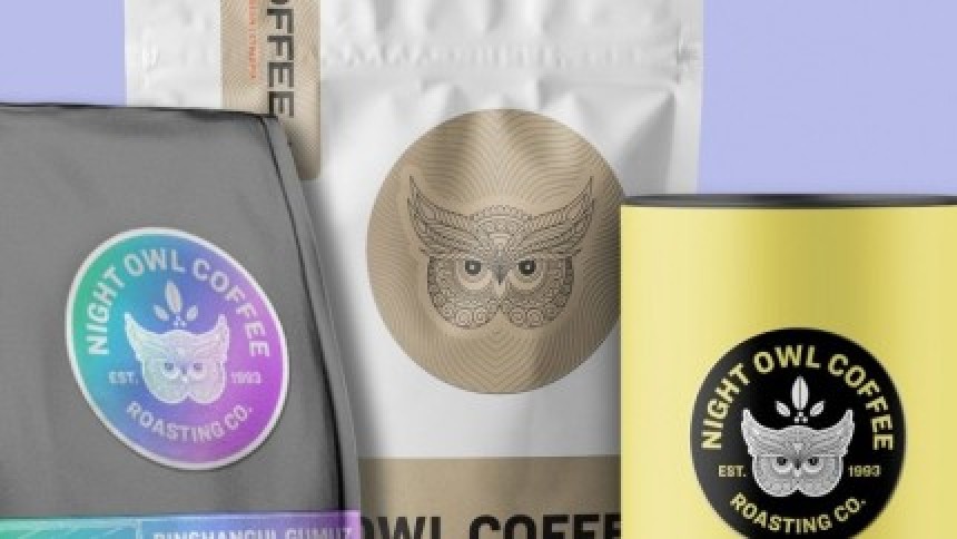 Različita pakiranja kave brenda "Night Owl Coffee" koja demonstriraju upotrebu etiketa na različitim materijalima: holografska etiketa na sivoj vrećici, papirnata na bijeloj i crna na žutoj limenci.