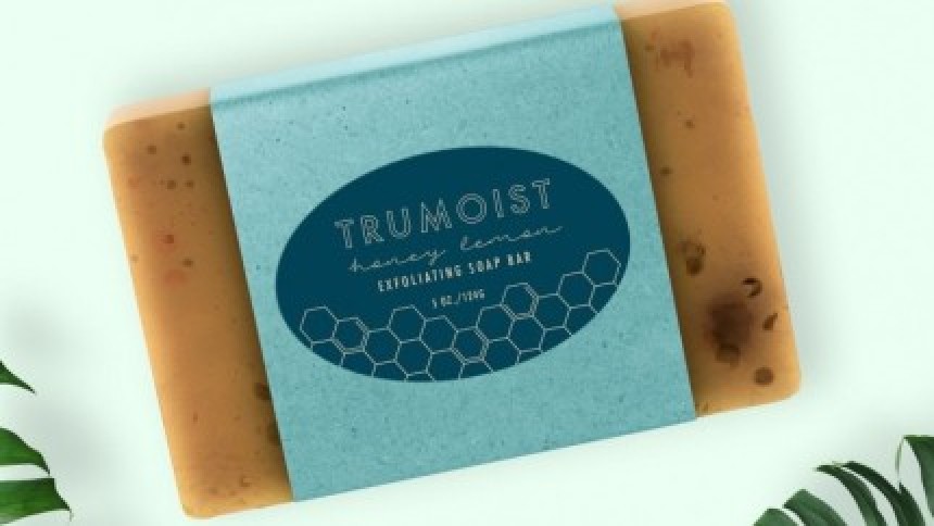 Ručno rađeni sapun od meda i limuna omotan plavom papirnatom etiketom u obliku trake s logotipom "TRUMOIST".