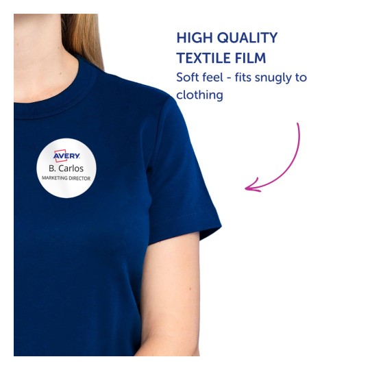 Slika prikazuje osobu u mornarsko plavoj košulji s okruglom oznakom na kojoj piše 'B. Carlos, DIREKTOR MARKETINGA'. Nalazi se tekst koji promovira 'Visokokvalitetni tekstilni film' s opisom da ima mekan osjećaj i dobro prianja uz odjeću.