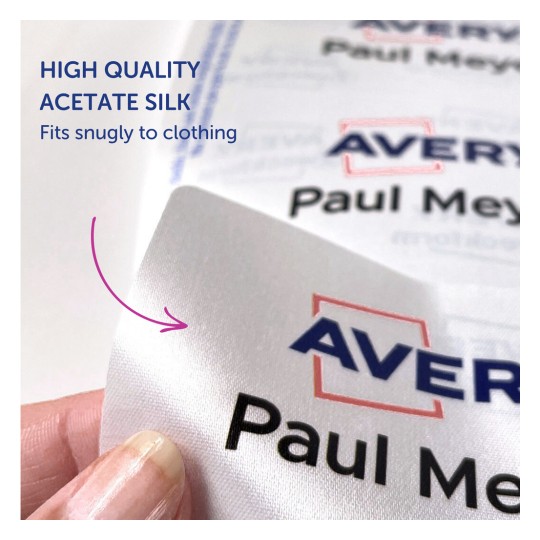 Slika prikazuje komad tkanine označen kao visokokvalitetna acetatna svila. Fokusirana je na teksturu izbliza. Oznaka sadrži ime 'Paul Meyer' i marku 'Avery', što ukazuje na to da se dobro prilagođava odjeći.