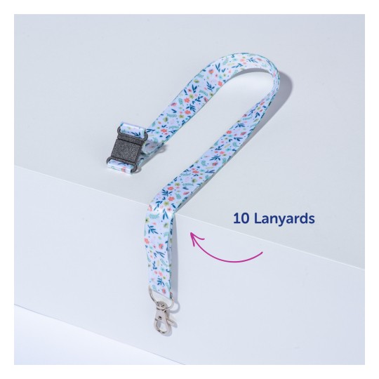 Slika prikazuje šareni privjesak s cvjetnim uzorkom i kopčom. Postavljena je na ravnu površinu, s oznakom na kojoj piše '10 privjesaka'.