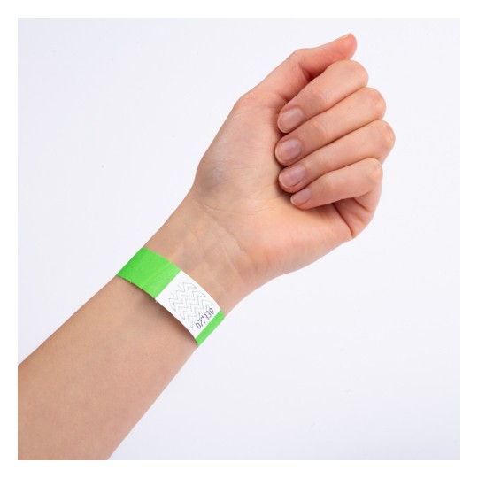 Bliski prikaz ruke s zelenom narukvicom na zapešću. Narukvica ima bijeli dio sa cik-cak dizajnom i čini se da je označena brojem.