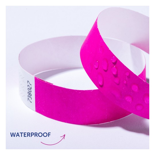Slika prikazuje dvije ružičaste vodootporne narukvice s kapima vode na jednoj od njih. Ona prenosi vodootpornu prirodu narukvica.