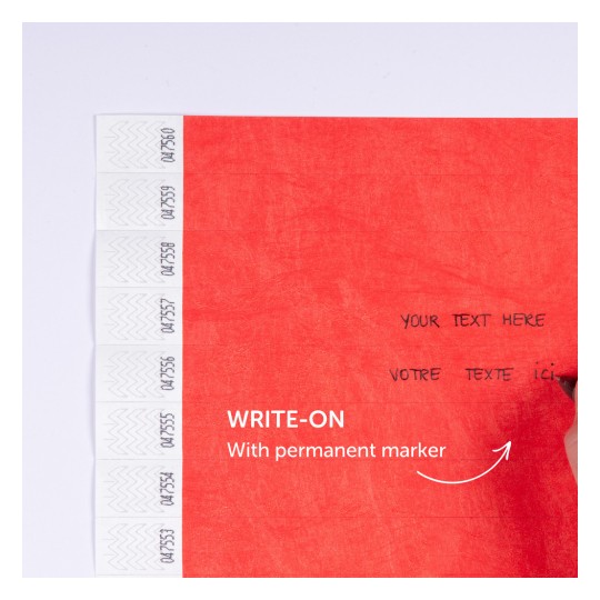 Slika prikazuje crvenu površinu s linijama za pisanje. Sadrži oznaku koja navodi da se na nju piše trajnim markerom, a ima dvojezični tekst: 'YOUR TEXT HERE' i 'VOTRE TEXTE ICI'.
