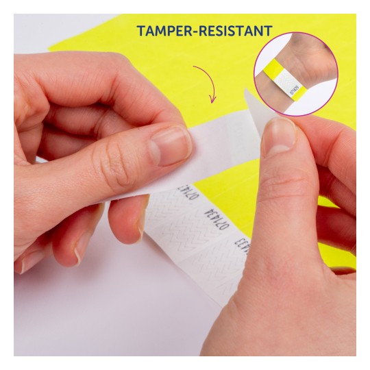 Slika prikazuje osobu koja skida naljepnicu otpornu na neovlašteno otvaranje s podloge. Naljepnica ima cik-cak uzorak i postavljena je na svijetložutu pozadinu.