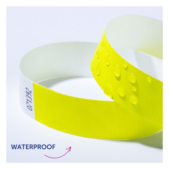 Slika prikazuje žutu vodonepropusnu narukvicu s kapljicama vode na površini, što ukazuje na njezinu otpornost na vodu.