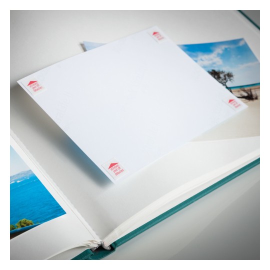 Slika prikazuje otvoreni foto album s praznom stranicom spremnom za dodavanje fotografije. Album sadrži slike plaže i morskih pejzaža, a prazna stranica je istaknuta.