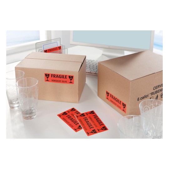 Slika prikazuje dvije kartonske kutije s oznakom 'KRHKO' s čašama pored njih na stolu.