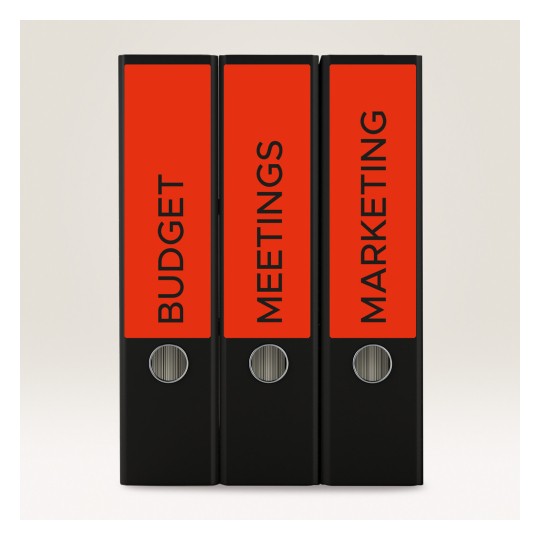 Slika prikazuje tri crna registratora s jarko crvenim etiketama nazvanim 'PRORAČUN', 'SASTANCI' i 'MARKETING'. Registratori su okomito posloženi na jednostavnoj pozadini.