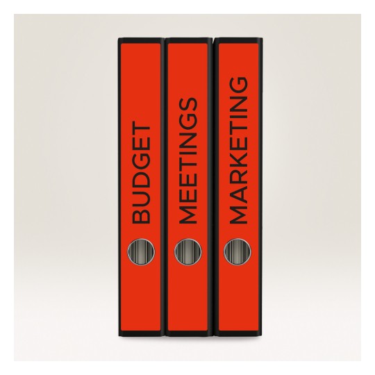 Slika prikazuje tri crvena registratora s natpisima 'PRORAČUN', 'SASTANCI' i 'MARKETING'. Postavljeni su vertikalno na svijetlu pozadinu.