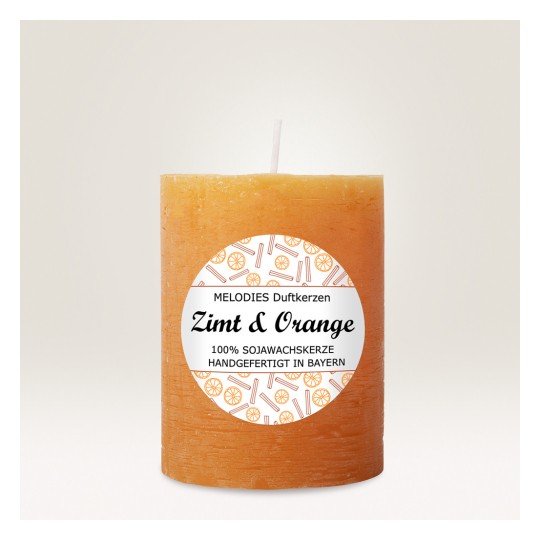Slika prikazuje cilindričnu, narančastu svijeću s oznakom 'Zimt & Orange' s dizajnom naranči i štapića cimeta. Izrađena je od 100% sojinog voska i ručno izrađena u Bavarskoj.