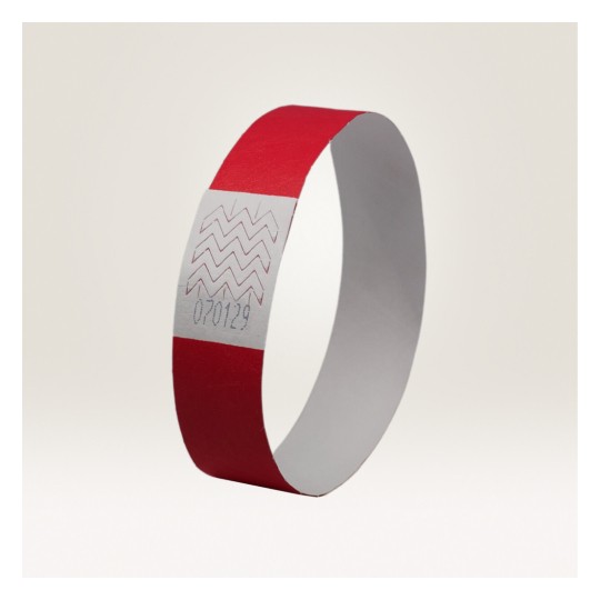 Slika prikazuje crvenu narukvicu. Narukvica ima bijeli dio sa cik-cak uzorcima i broj prikazan na njemu, što vjerojatno označava identifikacijski broj.