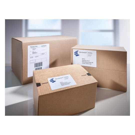 Slika prikazuje nekoliko smeđih kartonskih kutija, neke složene jedna na drugu, s naljepnicama za dostavu koje uključuju imena i adrese primatelja. Okruženje izgleda svijetlo i čisto.