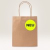 Slika prikazuje smeđu papirnatu vrećicu za kupovinu s kružnom neonsko žutom etiketom na kojoj je riječ 'NEU' crnim fontom.