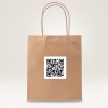 Slika prikazuje smeđu papirnatu vrećicu s naljepnicom QR koda na njoj. Vrećica ima dvije upletene papirnate ručke i postavljena je na svijetlu pozadinu.